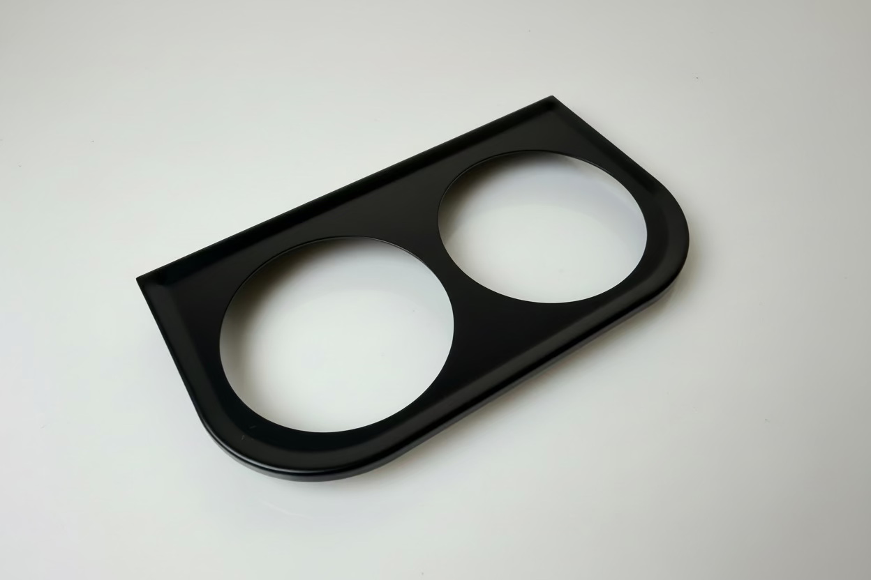 Black car dashboard panel with two circular cutouts on a white background