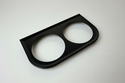 Black car dashboard panel with two circular cutouts on a white background